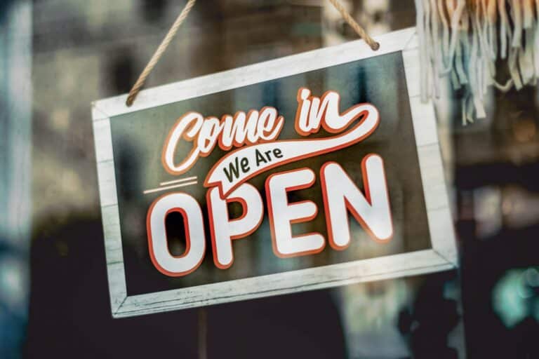 Home 2 154 Come in, we are open sign hanging in a business storefront window