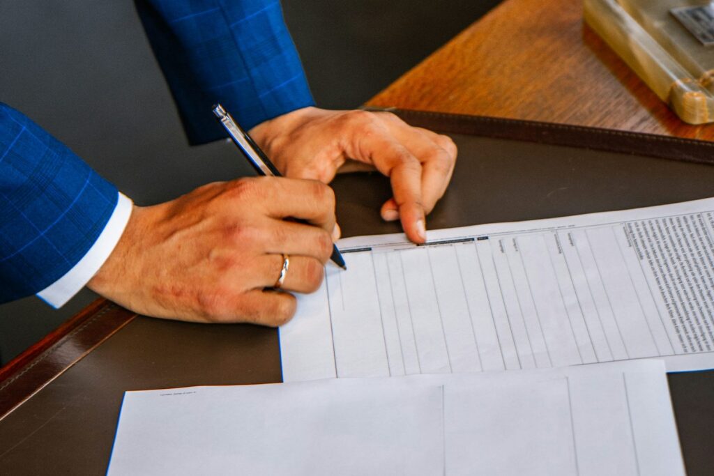 Business owner in a suit signing a printed credit application form