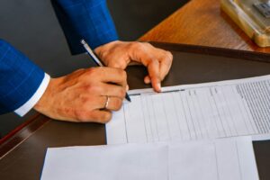 Business owner in a suit signing a printed credit application form